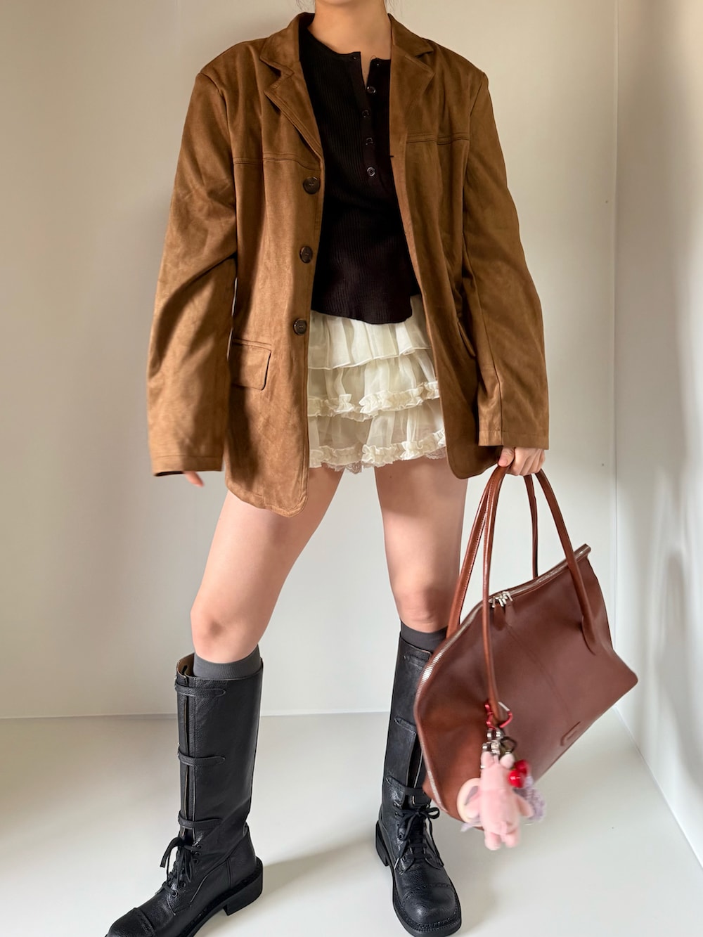 ブラック系のカーディガン/ボレロ、ブラウン系のテーラードジャケット、ホワイト系のスカートを着用したレディースの春コーディネートの3枚目の写真