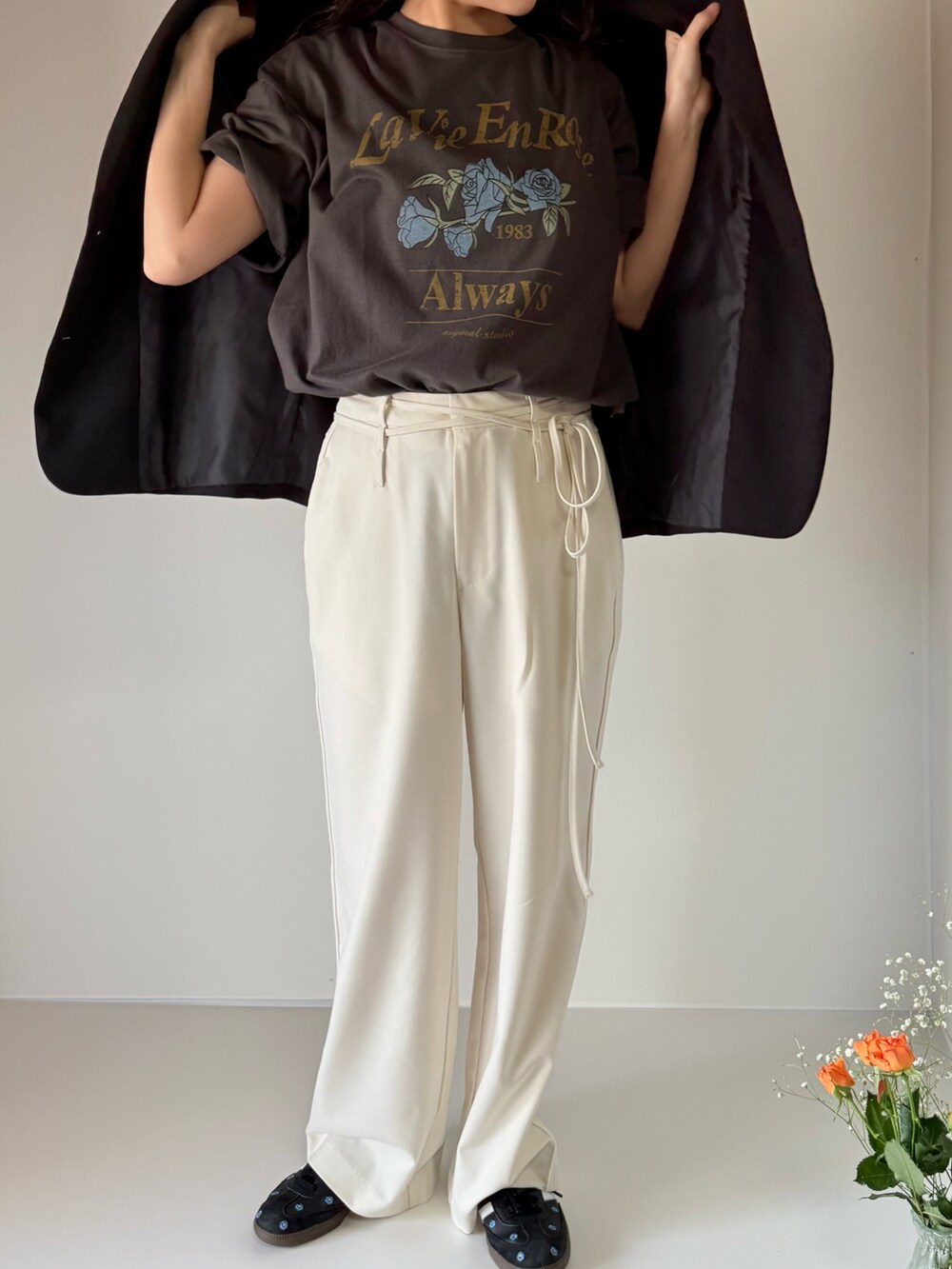 グレー系のTシャツ/カットソー、ホワイト系のスラックス、ブラック系のスニーカーを着用したレディースの春コーディネートの4枚目の写真