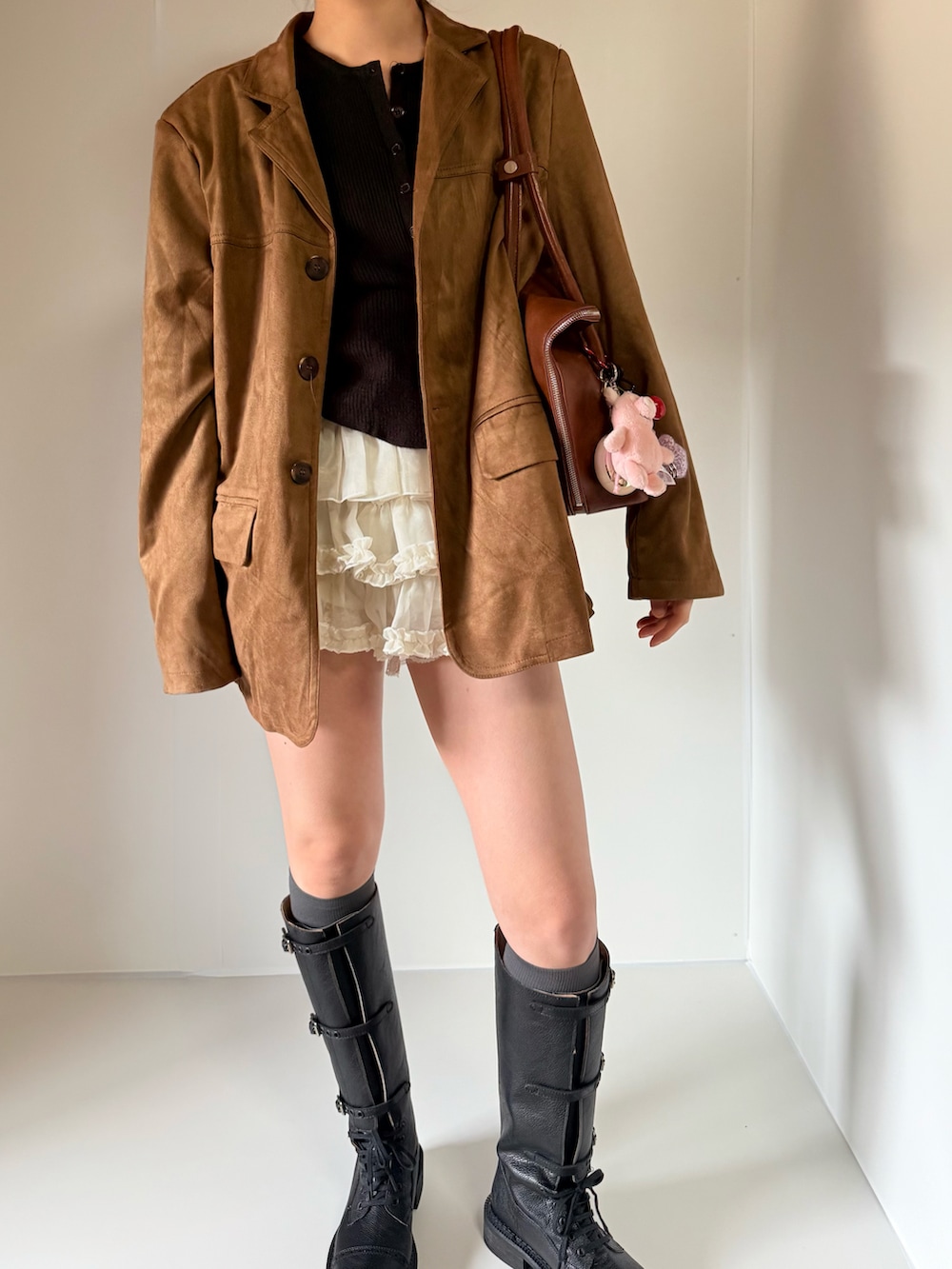 ブラック系のカーディガン/ボレロ、ブラウン系のテーラードジャケット、ホワイト系のスカートを着用したレディースの春コーディネートの2枚目の写真