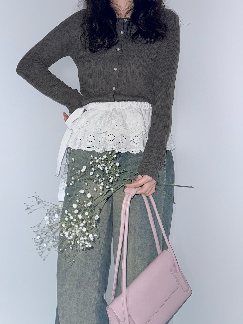 ブラウン系のカーディガン/ボレロ、ホワイト系のスカート、ブルー系のデニムパンツを着用したレディースの春コーディネートの3枚目の写真