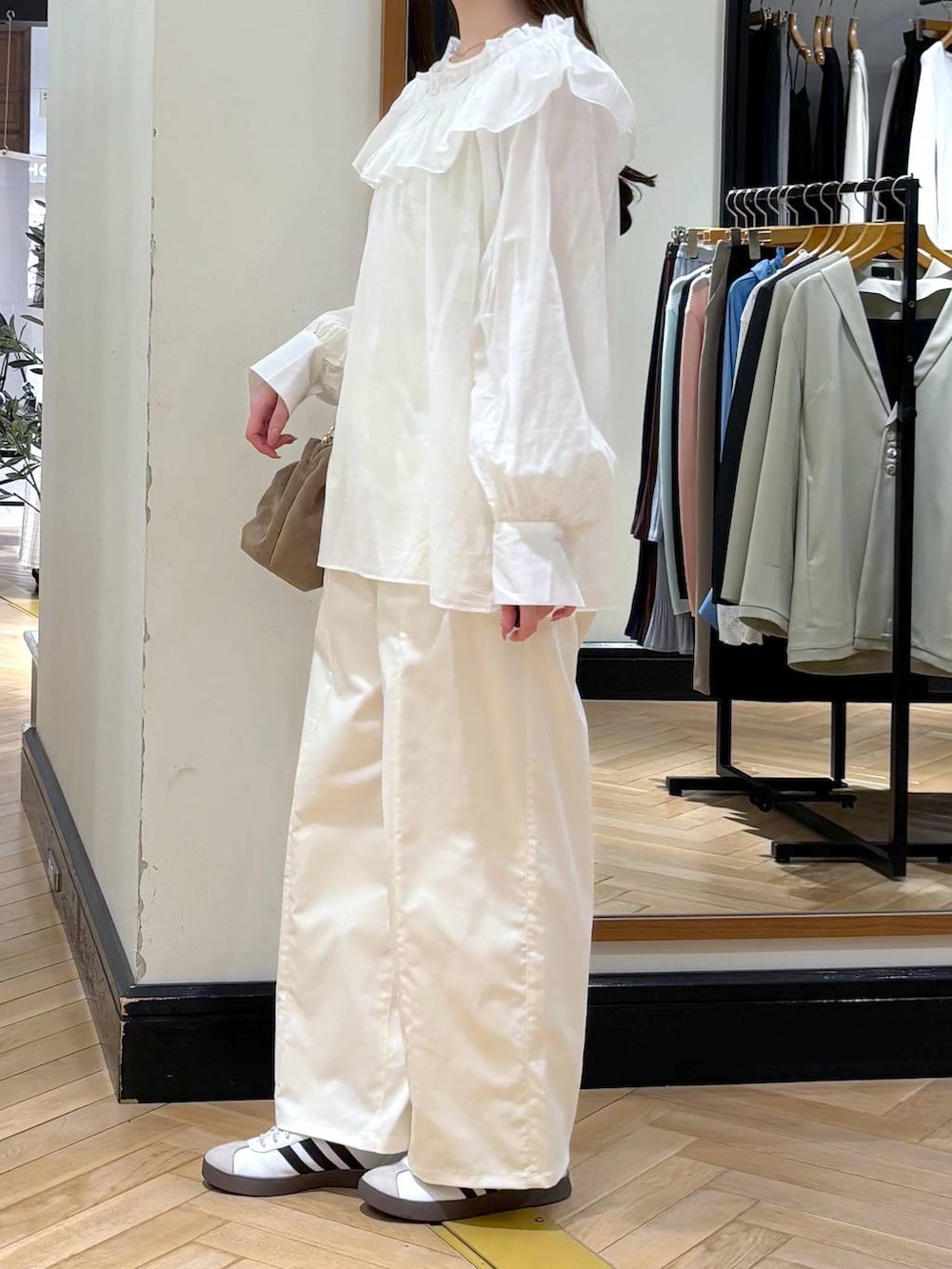 ベージュ系のショルダーバッグ、ホワイト系のTシャツ/カットソー、ホワイト系のスラックスを着用したレディースの春コーディネートの3枚目の写真