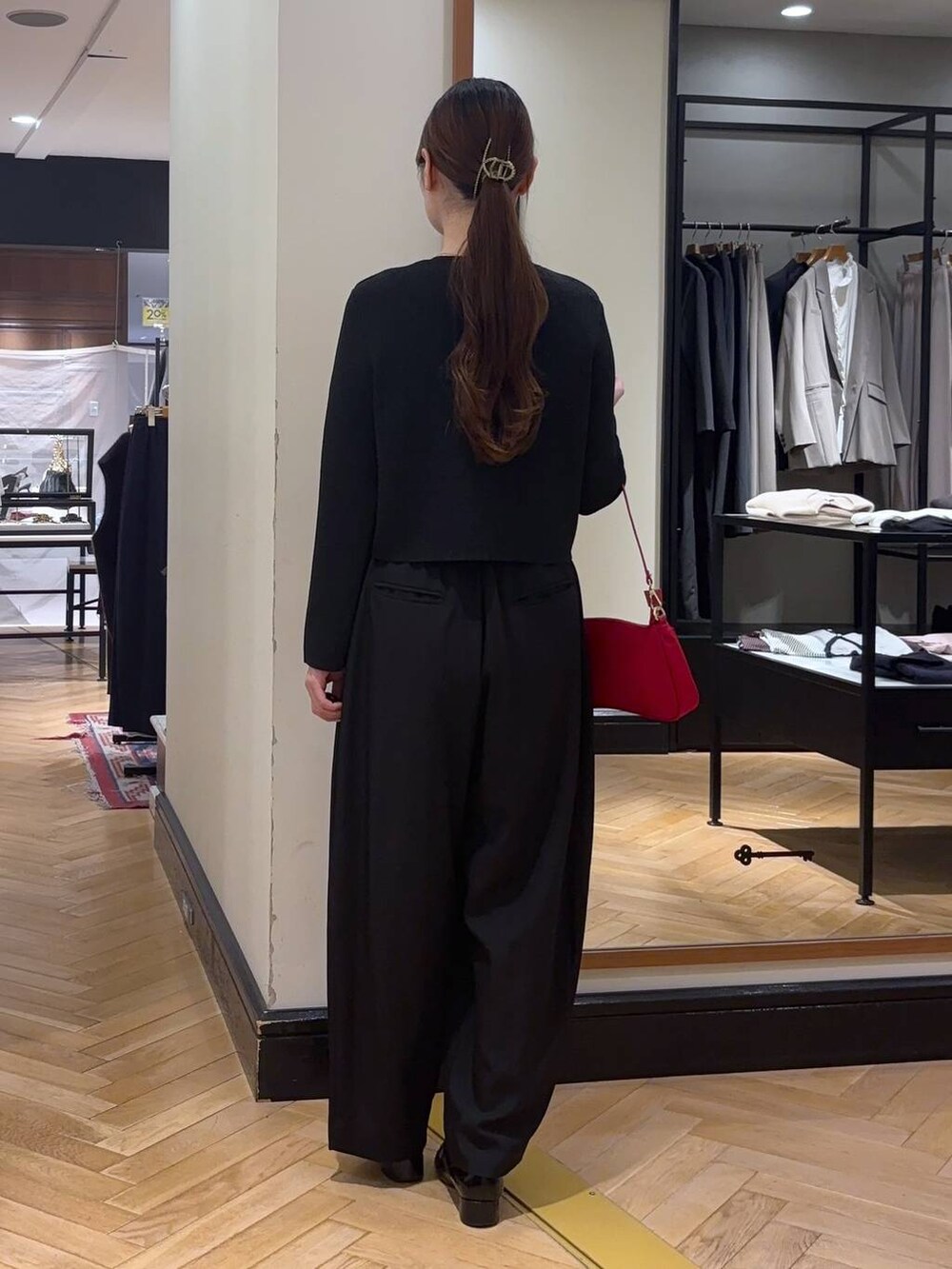 ブラック系のローファー、ブラック系のスラックス、レッド系のショルダーバッグを着用したレディースの秋コーディネートの5枚目の写真