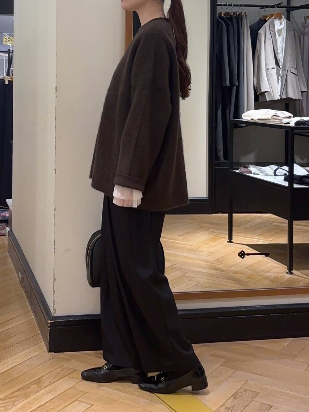 ブラウン系のカーディガン/ボレロ、ブラック系のローファー、ブラック系のスラックスを着用したレディースの秋コーディネートの5枚目の写真