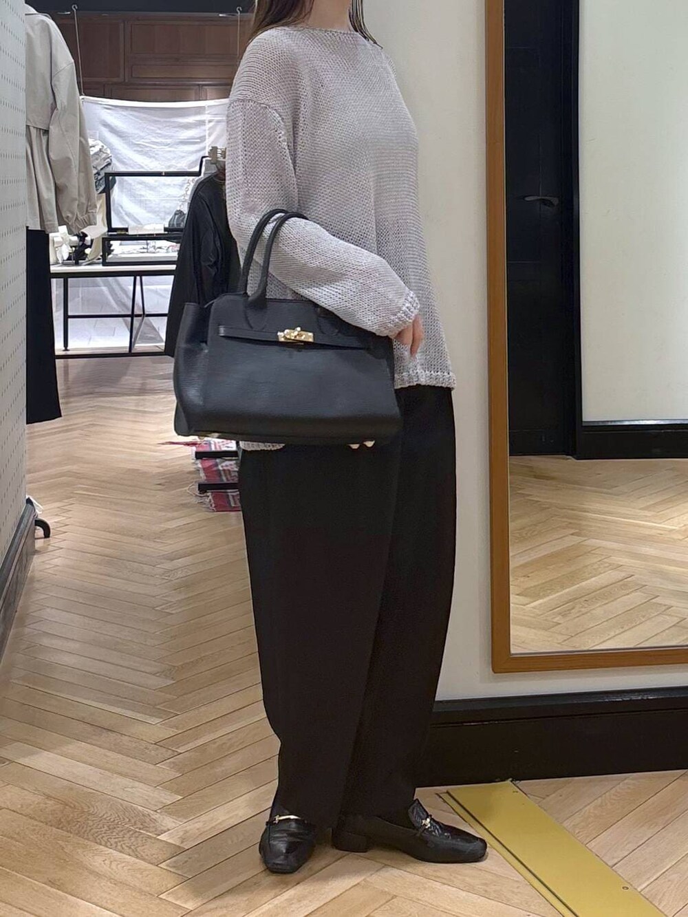 ブラック系のローファー、ブラック系のショルダーバッグ、ブラック系のチノパンツを着用したレディースの春コーディネートの2枚目の写真