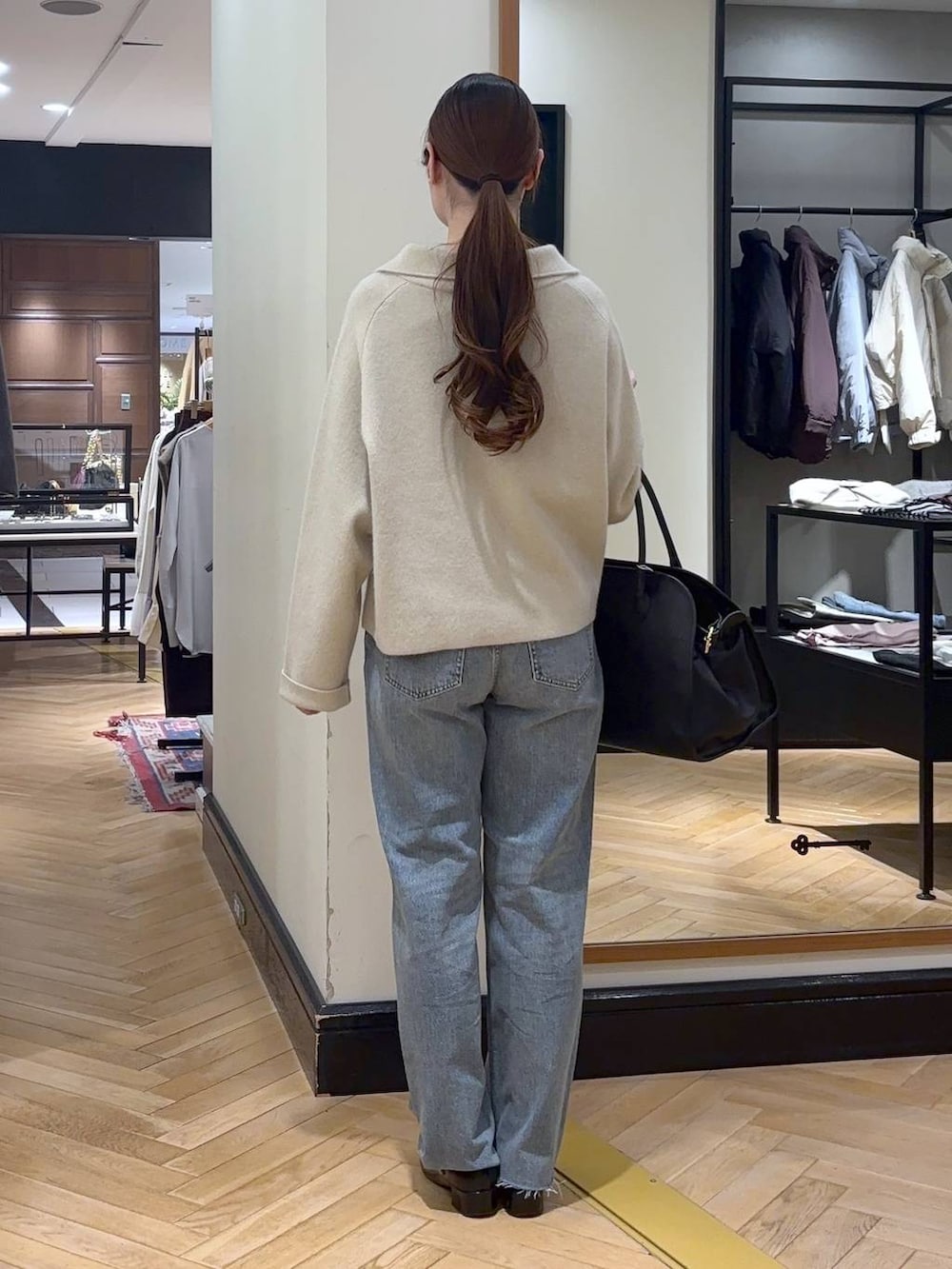 グレー系のTシャツ/カットソー、ブラック系のローファー、ブルー系のデニムパンツを着用したレディースの秋コーディネートの4枚目の写真