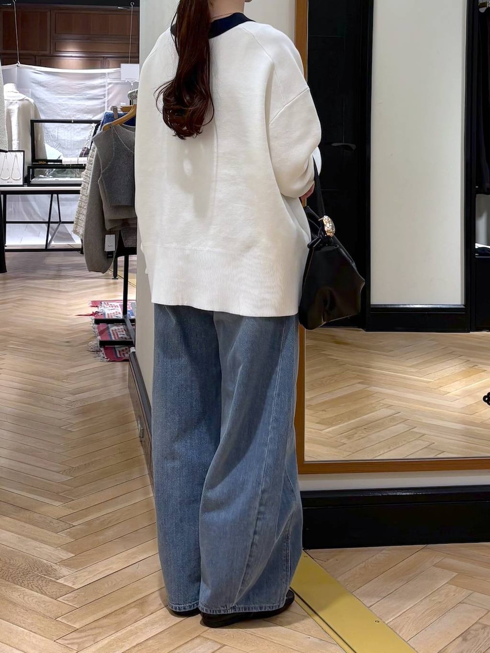 ブルー系のデニムパンツ、ブラック系のカーディガン/ボレロ、ブラック系のショルダーバッグを着用したレディースの冬コーディネートの4枚目の写真