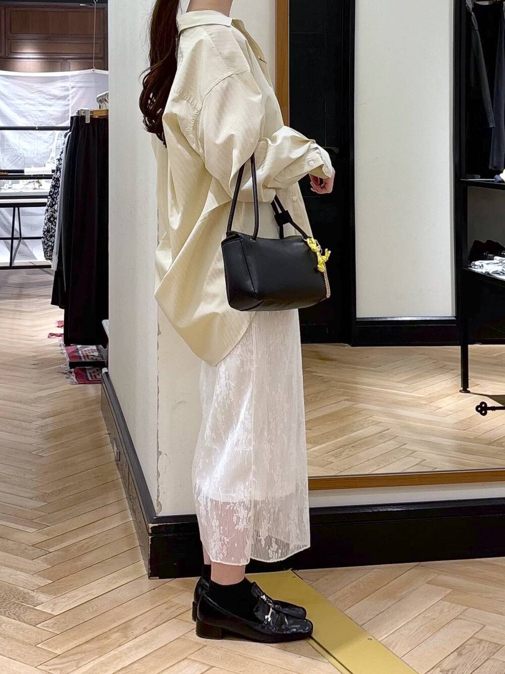 ブラック系のローファー、ホワイト系のスカート、イエロー系のシャツ/ブラウスを着用したレディースの冬コーディネートの3枚目の写真