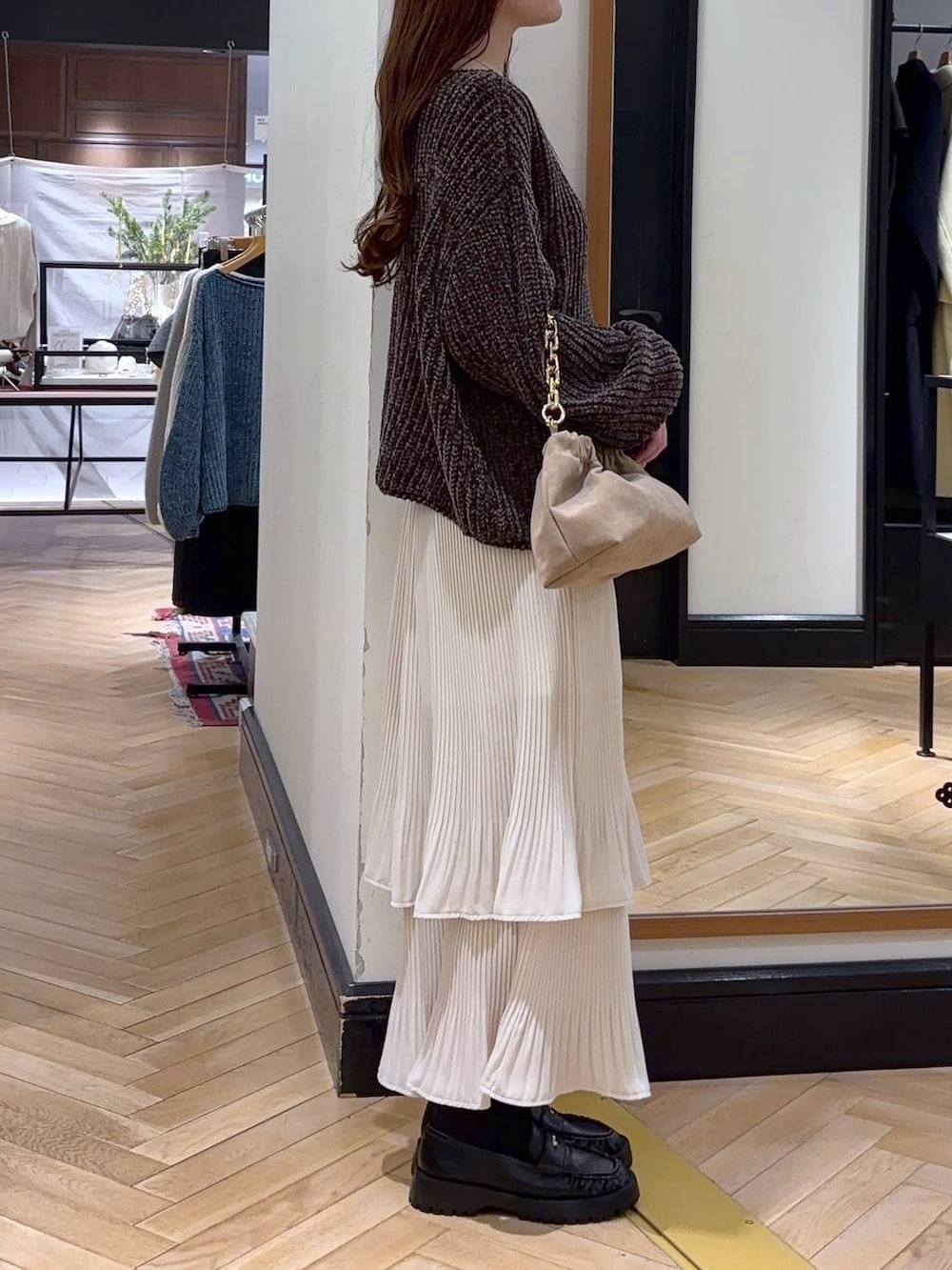ホワイト系のスカート、ブラウン系のニット/セーター、ベージュ系のショルダーバッグを着用したレディースの冬コーディネートの2枚目の写真