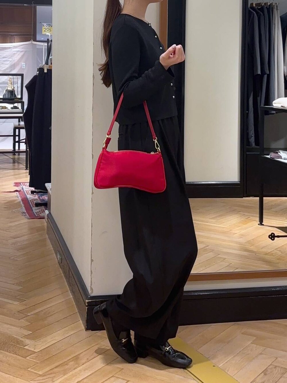 ブラック系のローファー、ブラック系のスラックス、レッド系のショルダーバッグを着用したレディースの秋コーディネートの2枚目の写真