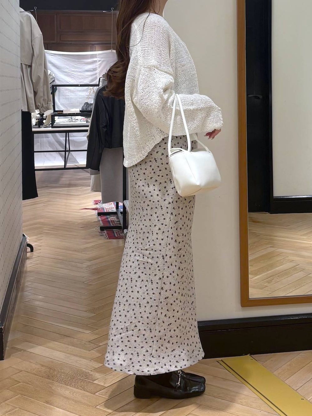 ブラック系のローファー、ホワイト系のショルダーバッグ、ホワイト系のカーディガン/ボレロを着用したレディースの春コーディネートの2枚目の写真