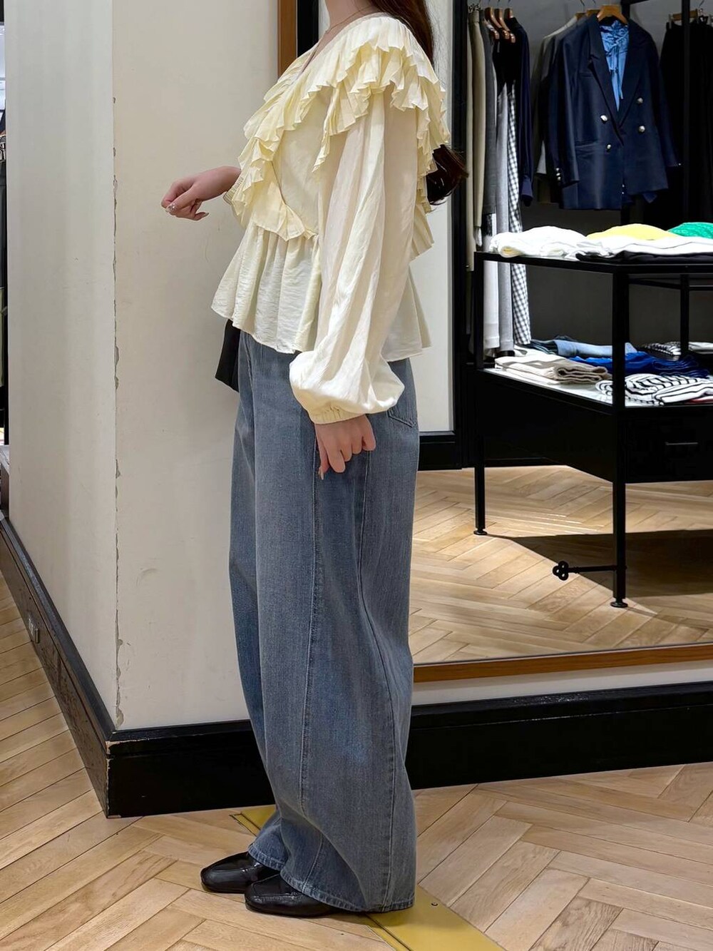 ブルー系のデニムパンツ、ブラック系のローファー、ブラック系のショルダーバッグを着用したレディースの春コーディネートの3枚目の写真