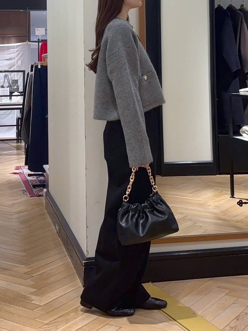 ブラック系のデニムパンツ、ブラック系のローファー、ブラック系のショルダーバッグを着用したレディースの秋コーディネートの3枚目の写真