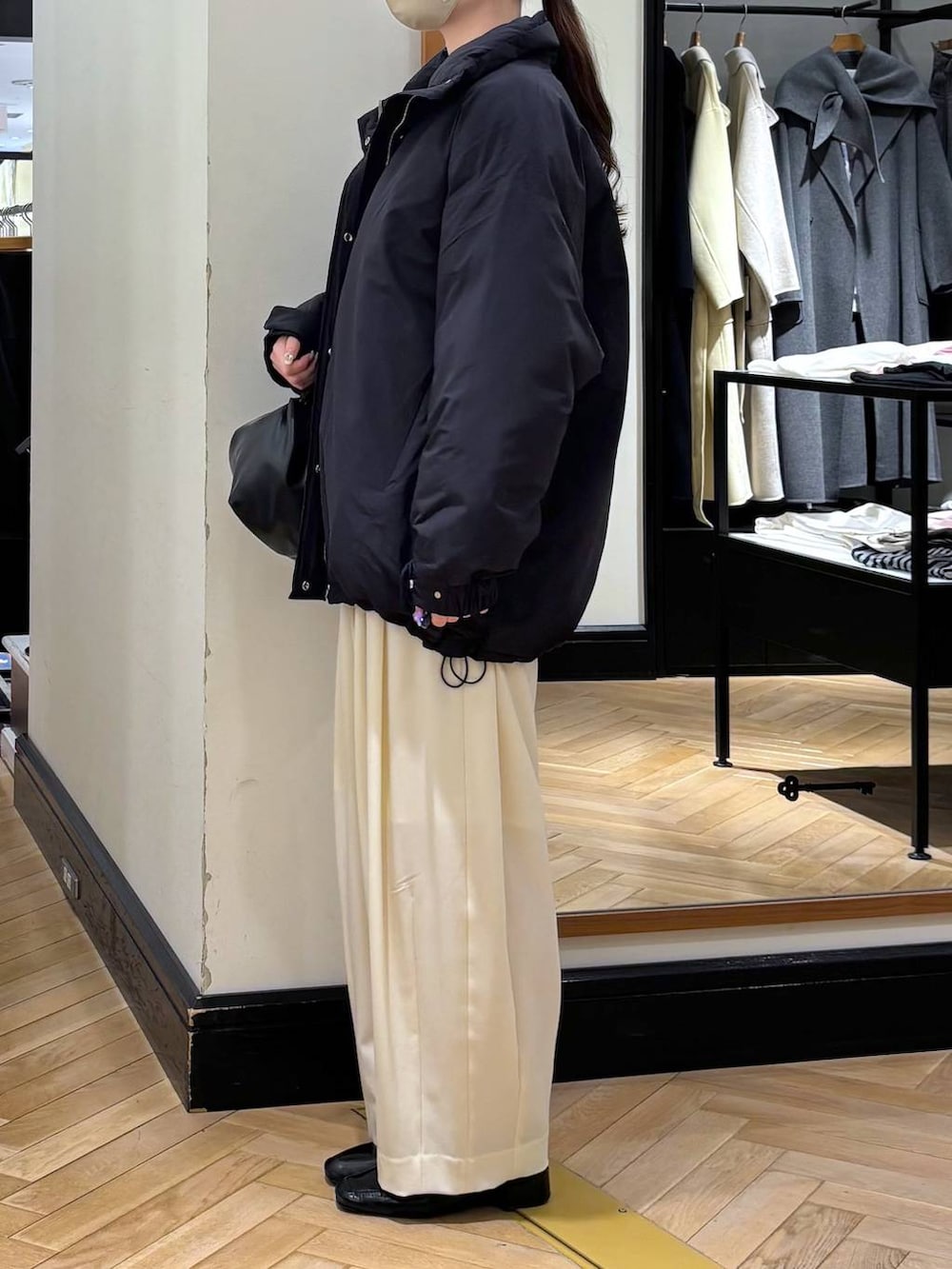 ホワイト系のスラックス、ブラック系のローファー、ブラック系のブルゾンを着用したレディースの冬コーディネートの3枚目の写真