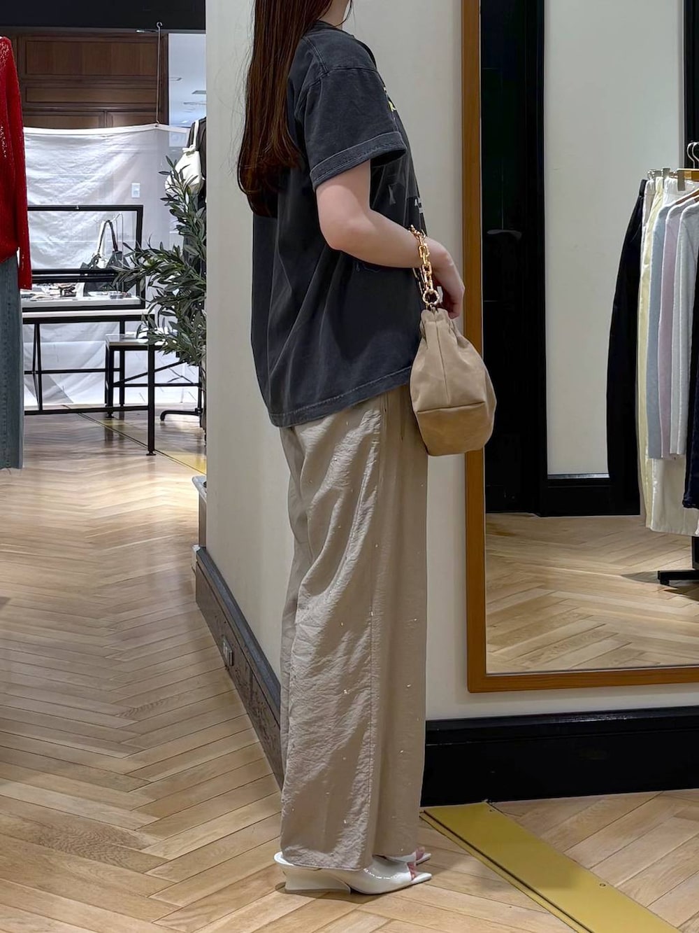 ベージュ系のショルダーバッグ、グレー系のTシャツ/カットソー、ホワイト系のサンダルを着用したレディースの春コーディネートの2枚目の写真