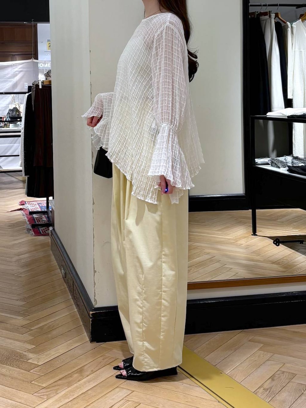 ブラック系のショルダーバッグ、ブラック系のサンダルを着用したレディースの春コーディネートの3枚目の写真