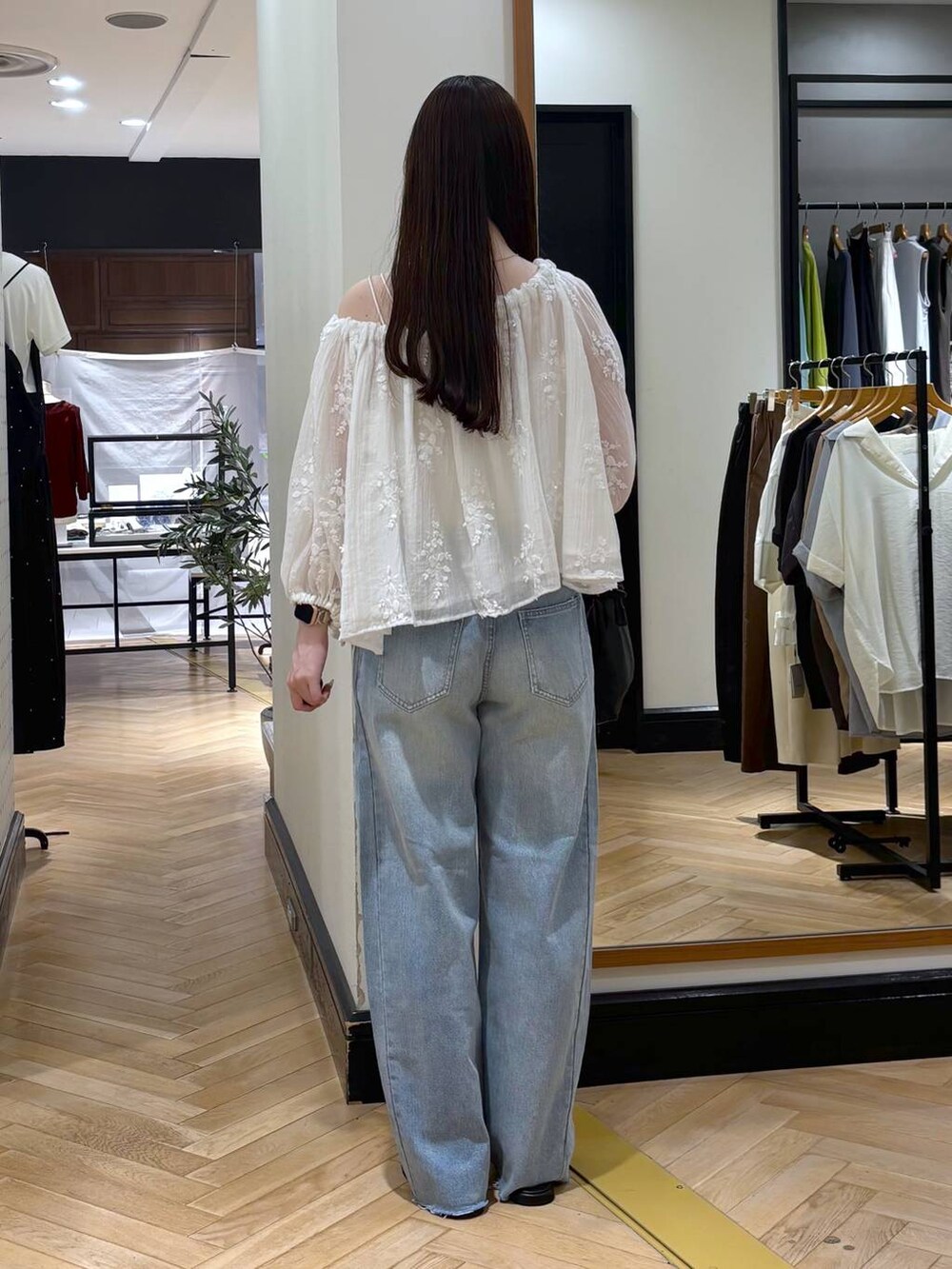 ホワイト系のシャツ/ブラウス、ブラック系のショルダーバッグ、ブルー系のデニムパンツを着用したレディースの夏コーディネートの4枚目の写真