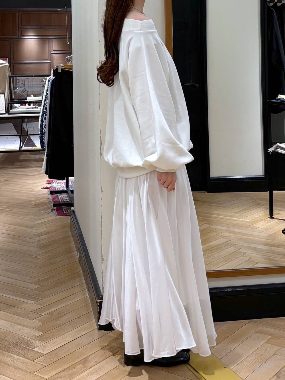 ブラック系のローファー、ホワイト系のスカート、ホワイト系のスウェットを着用したレディースの冬コーディネートの2枚目の写真