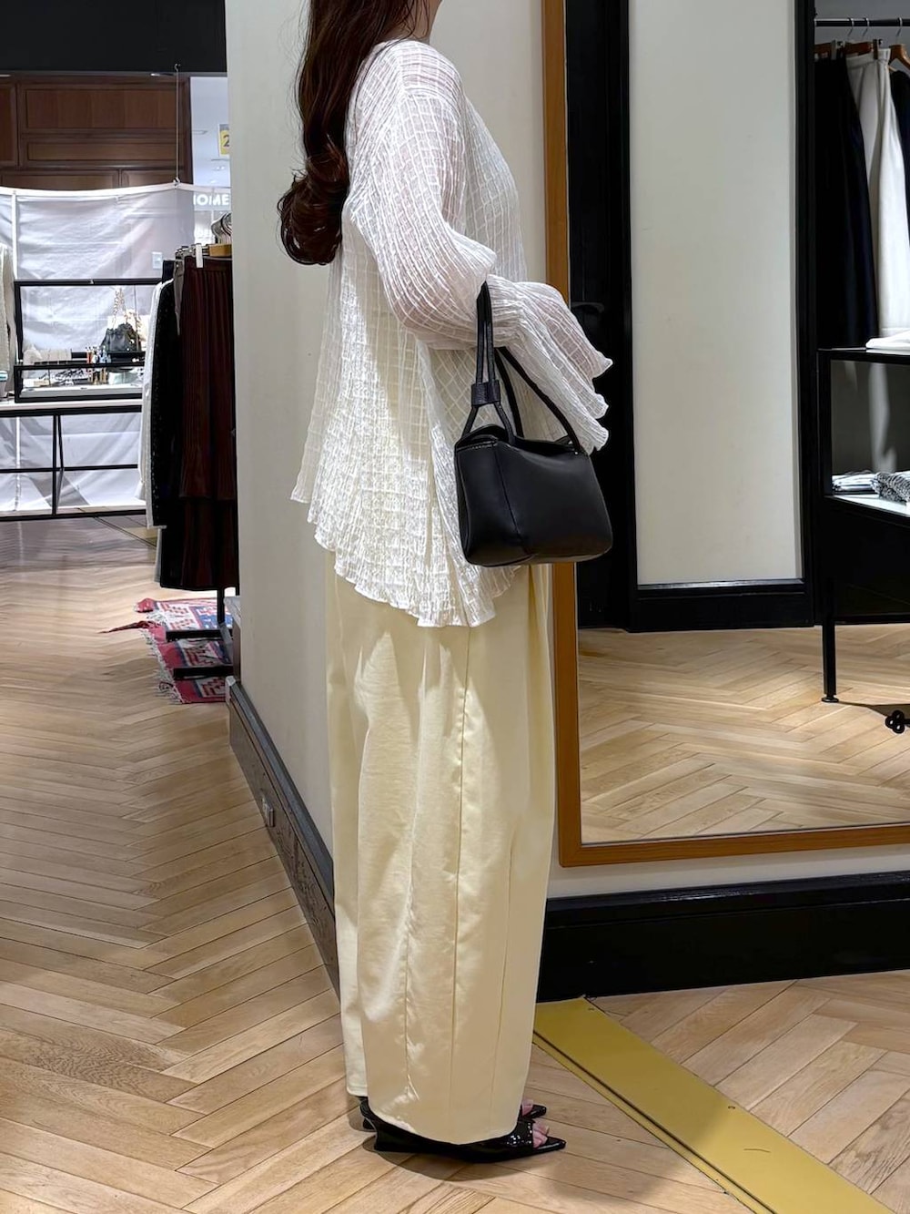 ブラック系のショルダーバッグ、ブラック系のサンダルを着用したレディースの春コーディネートの2枚目の写真