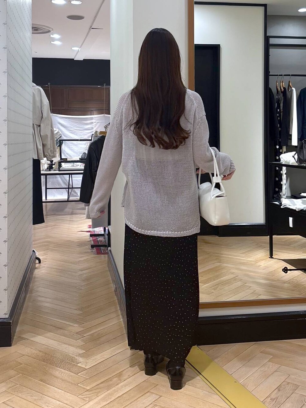 ブラック系のローファー、その他のスカート、ホワイト系のショルダーバッグを着用したレディースの春コーディネートの4枚目の写真