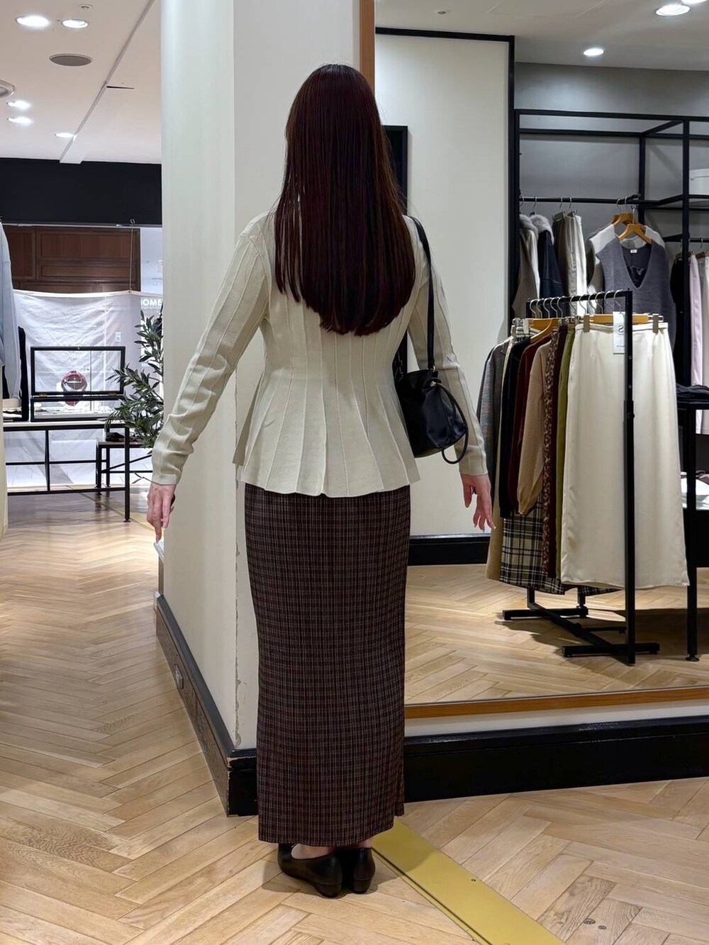 ブラック系のショルダーバッグ、ベージュ系のカーディガン/ボレロ、ブラック系のパンプスを着用したレディースの秋コーディネートの4枚目の写真