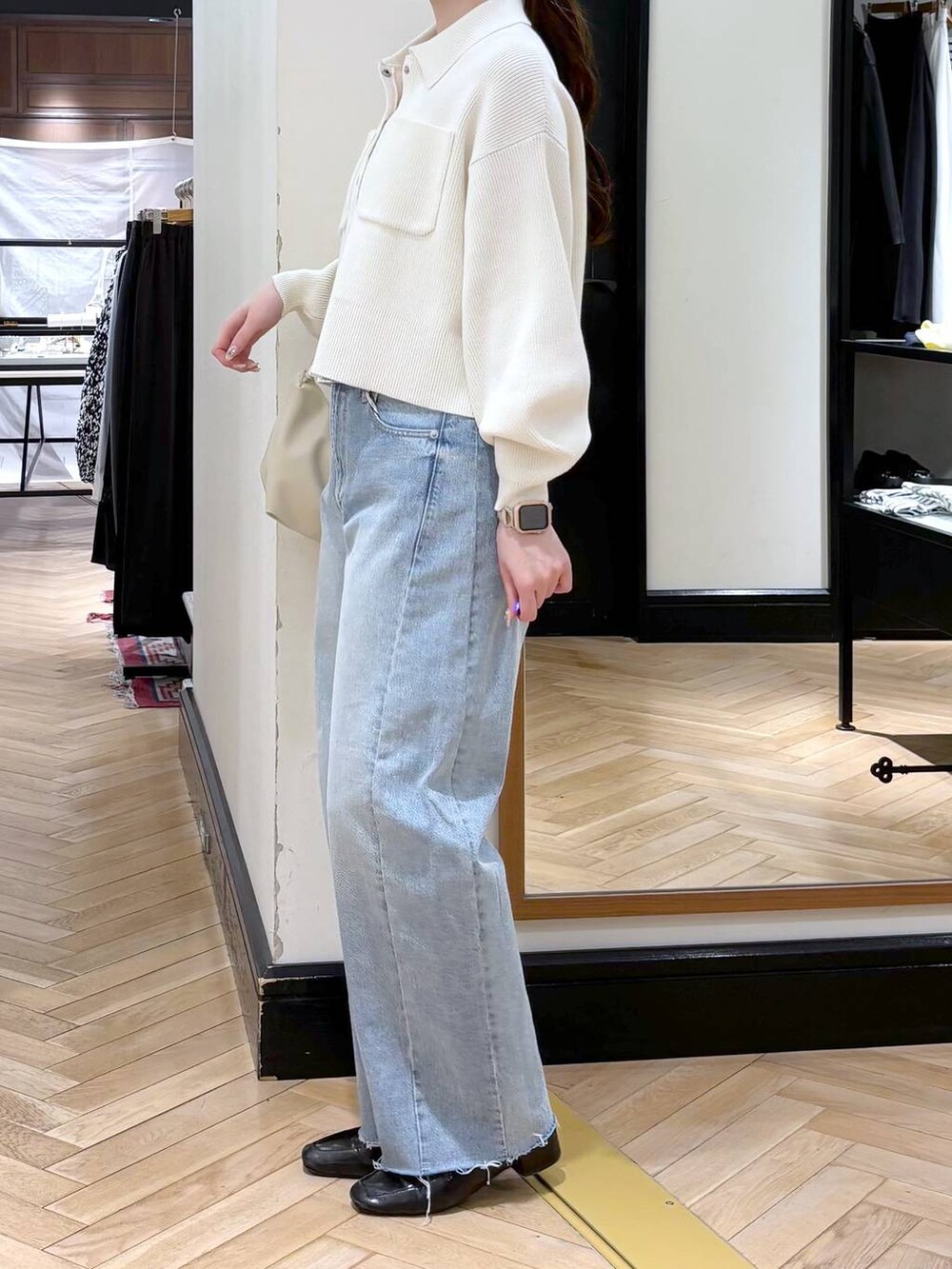 ブラック系のローファー、ブルー系のデニムパンツ、ホワイト系のカーディガン/ボレロを着用したレディースの冬コーディネートの4枚目の写真