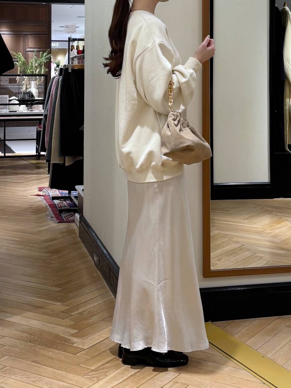 ブラック系のローファー、ホワイト系のスカート、ベージュ系のショルダーバッグを着用したレディースの冬コーディネートの2枚目の写真