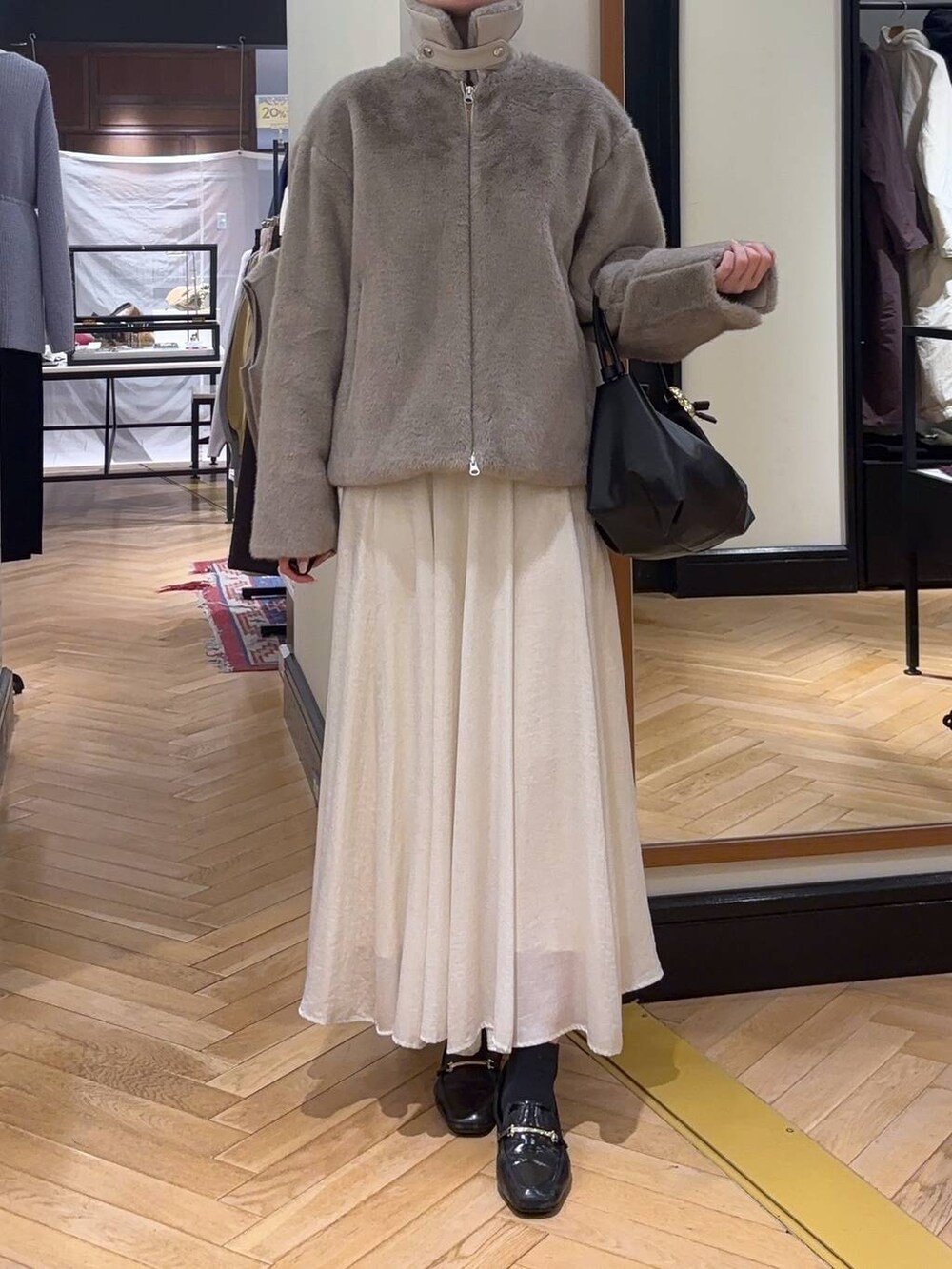 ブラック系のローファー、グレー系のその他アウター、ブラック系のショルダーバッグを着用したレディースの秋コーディネートの2枚目の写真