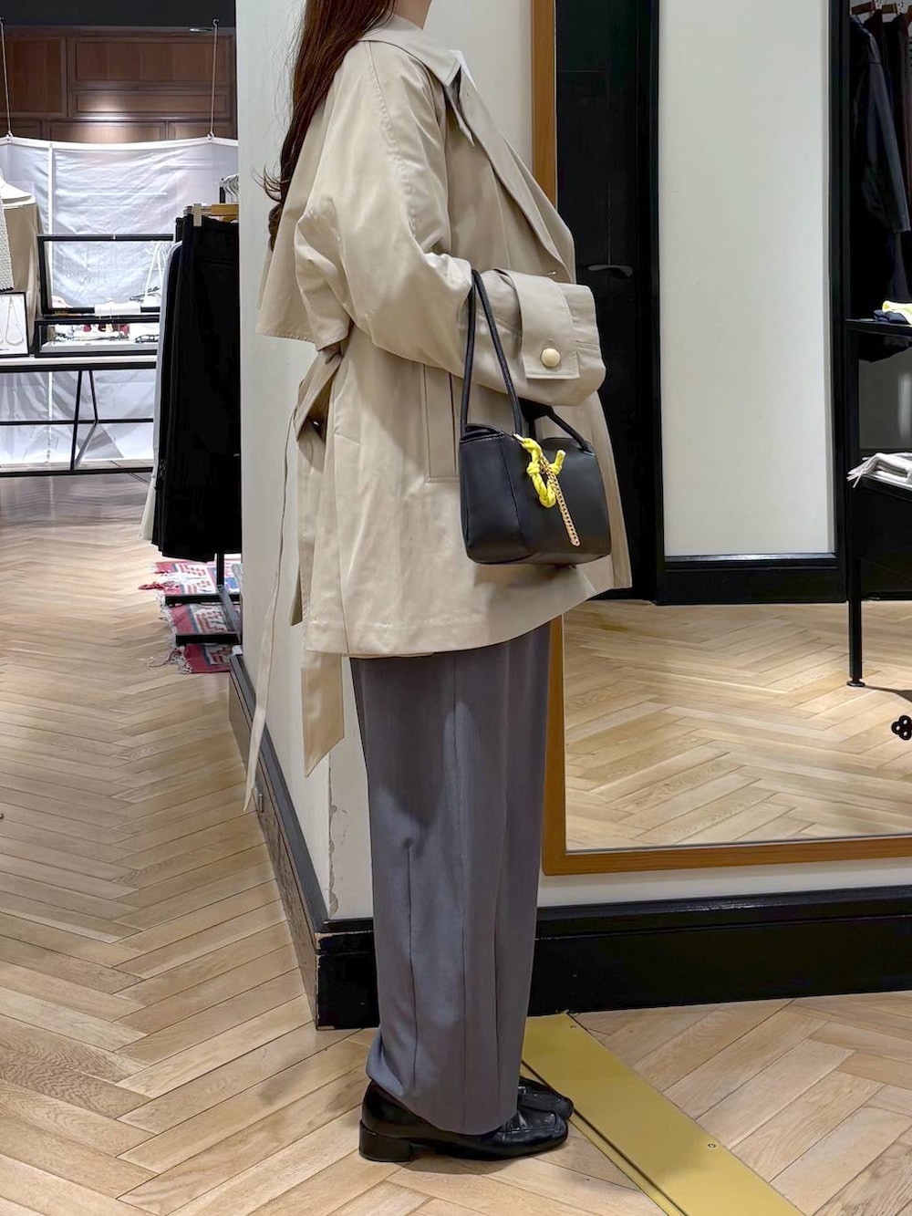 グレー系のスラックス、ブラック系のローファー、ホワイト系のシャツ/ブラウスを着用したレディースの冬コーディネートの3枚目の写真