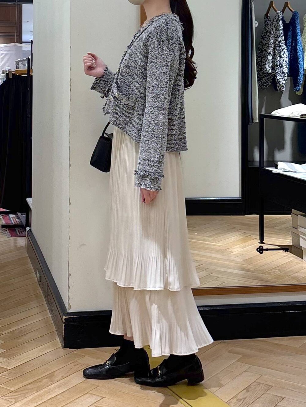 ホワイト系のスカート、ブラック系のローファー、ブラック系のカーディガン/ボレロを着用したレディースの冬コーディネートの4枚目の写真