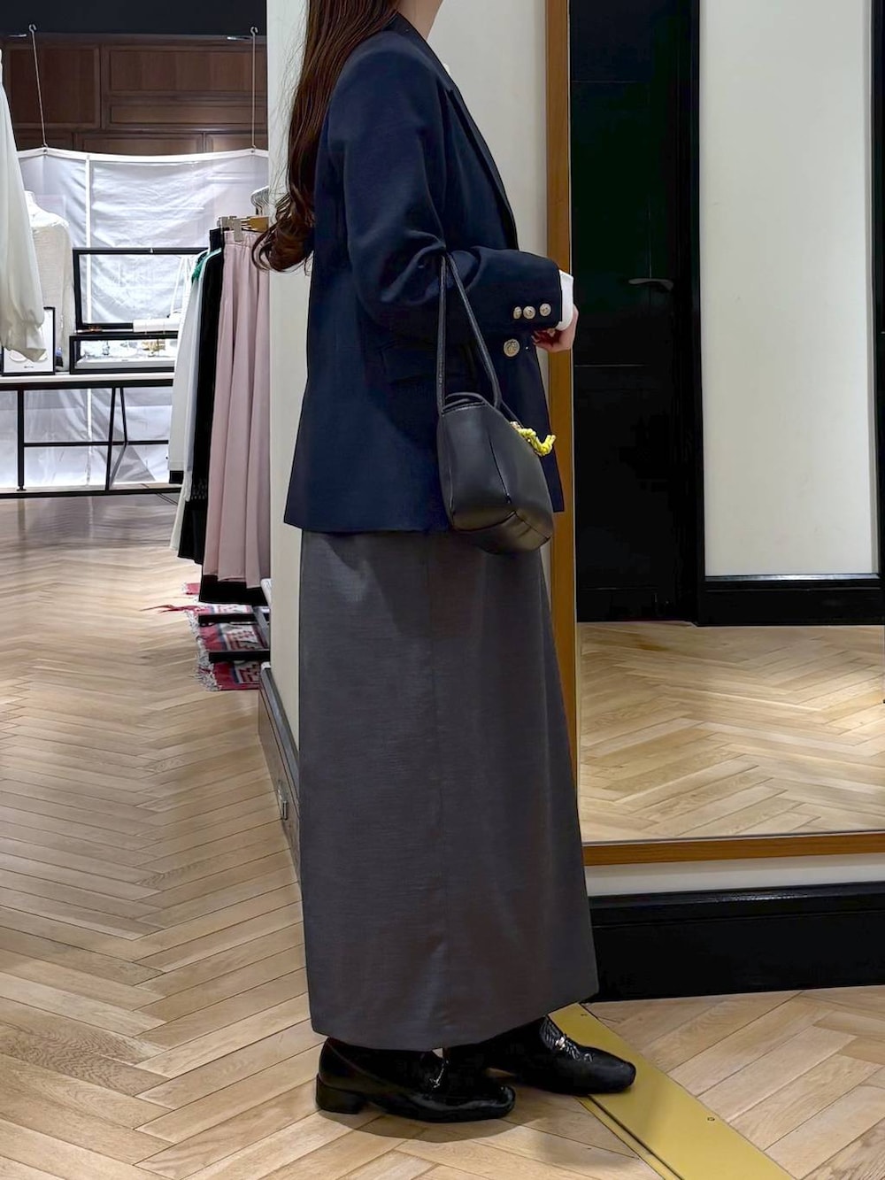 ブラック系のローファー、ベージュ系のテーラードジャケット、ブラック系のショルダーバッグを着用したレディースの春コーディネートの2枚目の写真