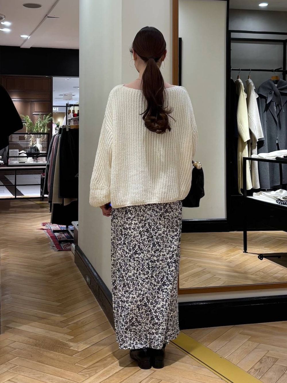 ブラック系のローファー、ホワイト系のニット/セーター、ブラック系のショルダーバッグを着用したレディースの冬コーディネートの4枚目の写真