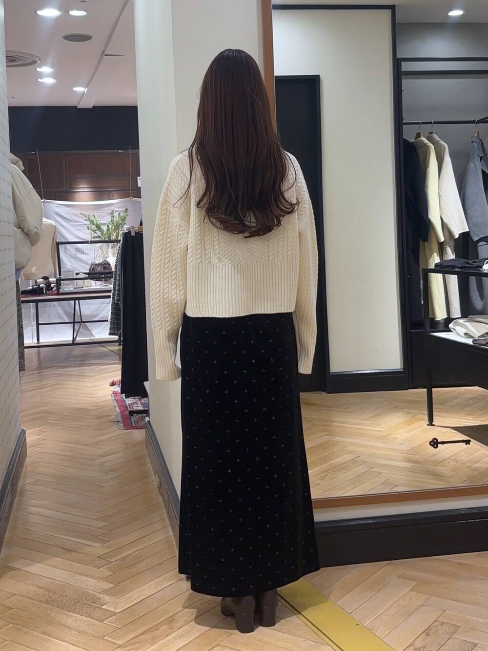 ホワイト系のピーコート、ブラウン系のブーツ、ホワイト系のニット/セーターを着用したレディースの冬コーディネートの6枚目の写真