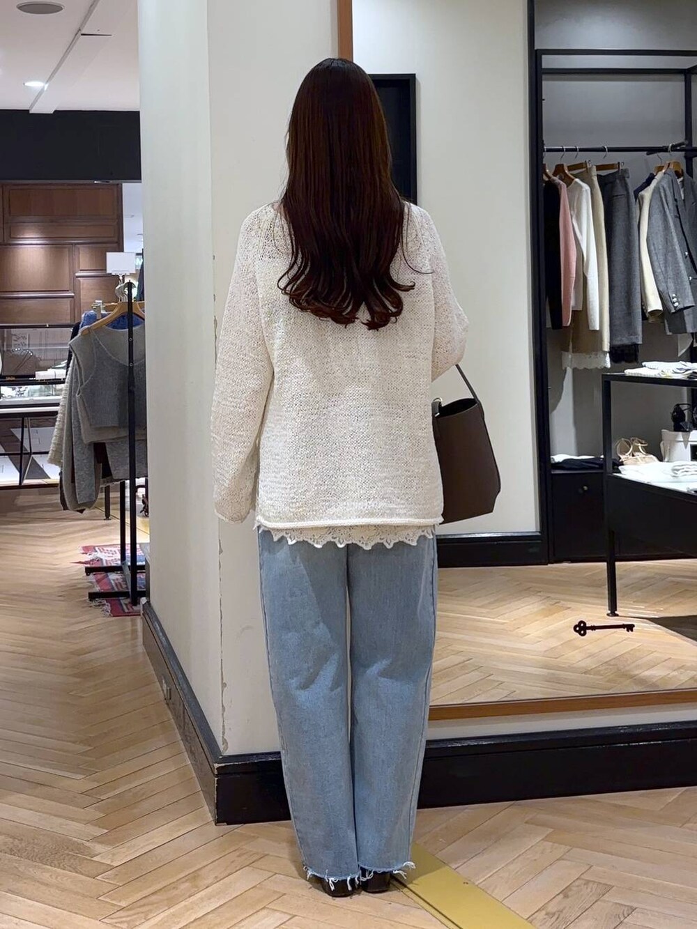 ブルー系のデニムパンツ、ブラック系のローファー、ホワイト系のキャミソールを着用したレディースの冬コーディネートの4枚目の写真