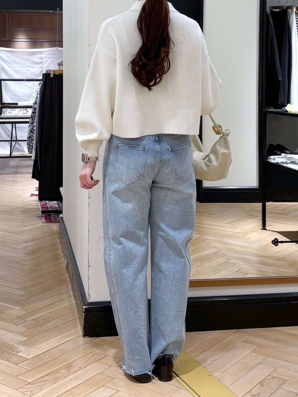 ブラック系のローファー、ブルー系のデニムパンツ、ホワイト系のカーディガン/ボレロを着用したレディースの冬コーディネートの5枚目の写真