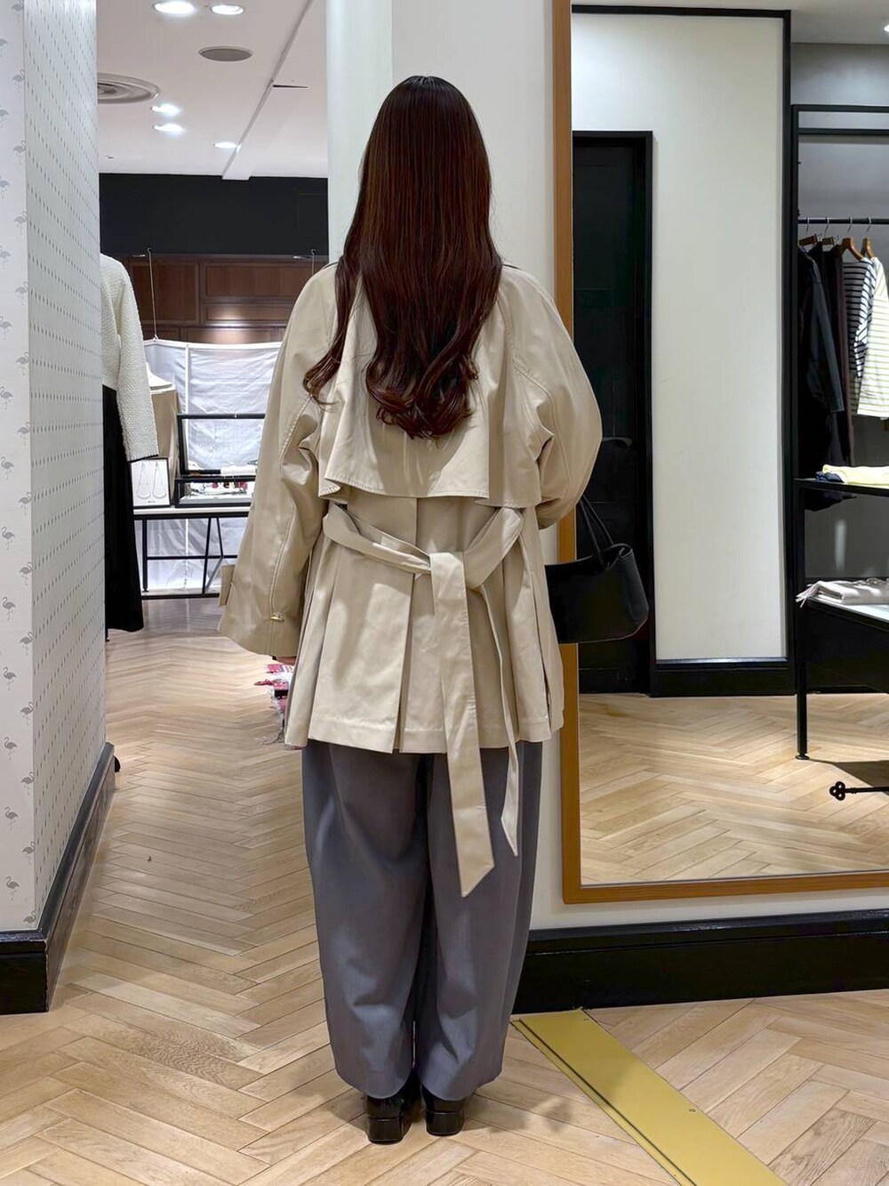 グレー系のスラックス、ブラック系のローファー、ホワイト系のシャツ/ブラウスを着用したレディースの冬コーディネートの6枚目の写真