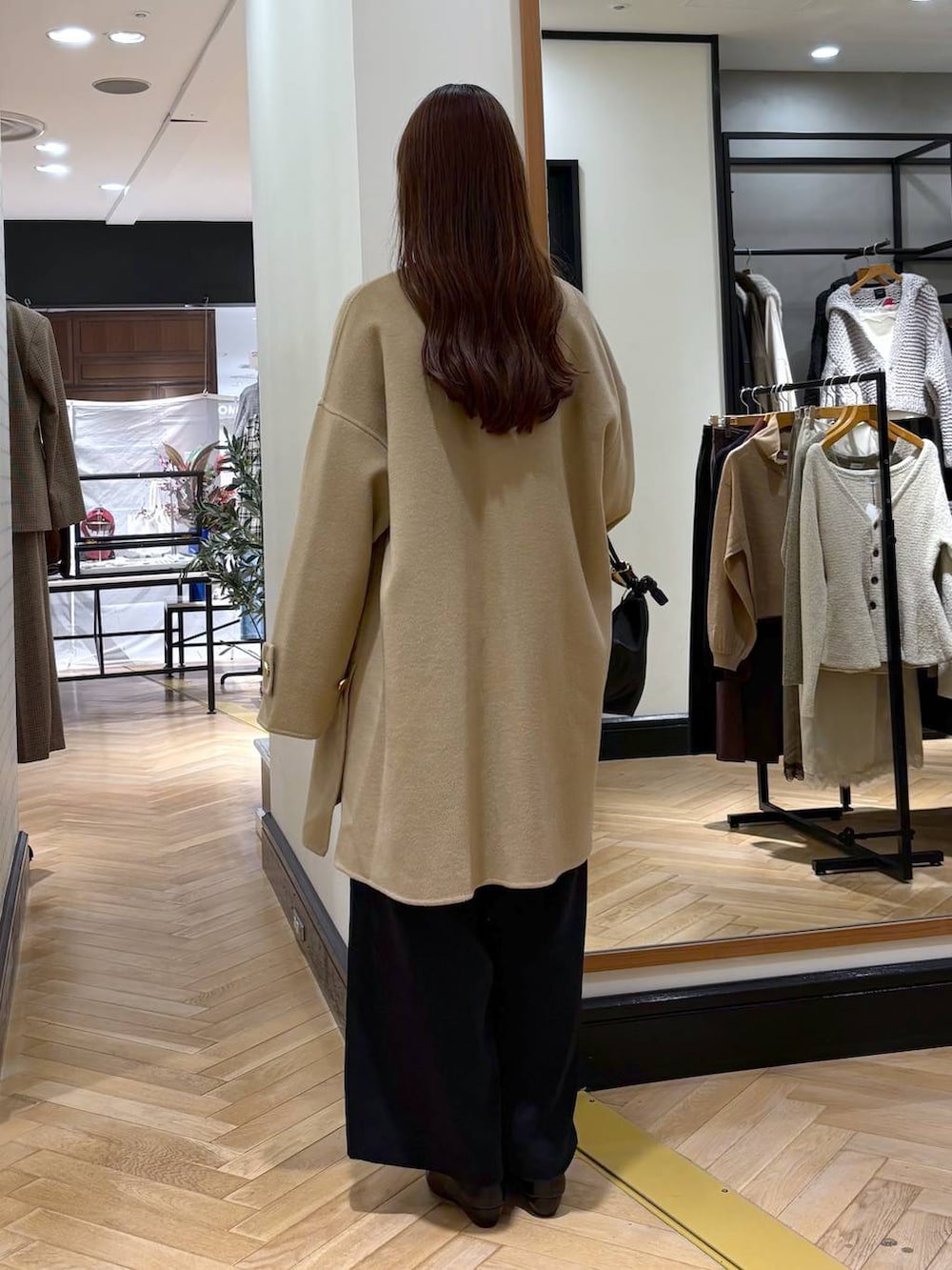 ブラック系のパンプス、ベージュ系のTシャツ/カットソー、ブラック系のスラックスを着用したレディースの秋コーディネートの4枚目の写真