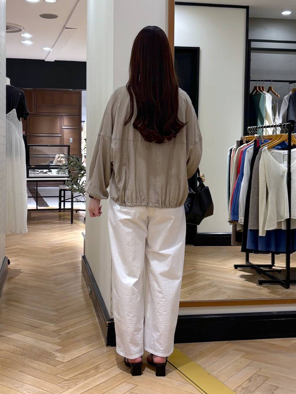 ブラック系のショルダーバッグ、ホワイト系のタンクトップ、ブラック系のサンダルを着用したレディースの春コーディネートの4枚目の写真