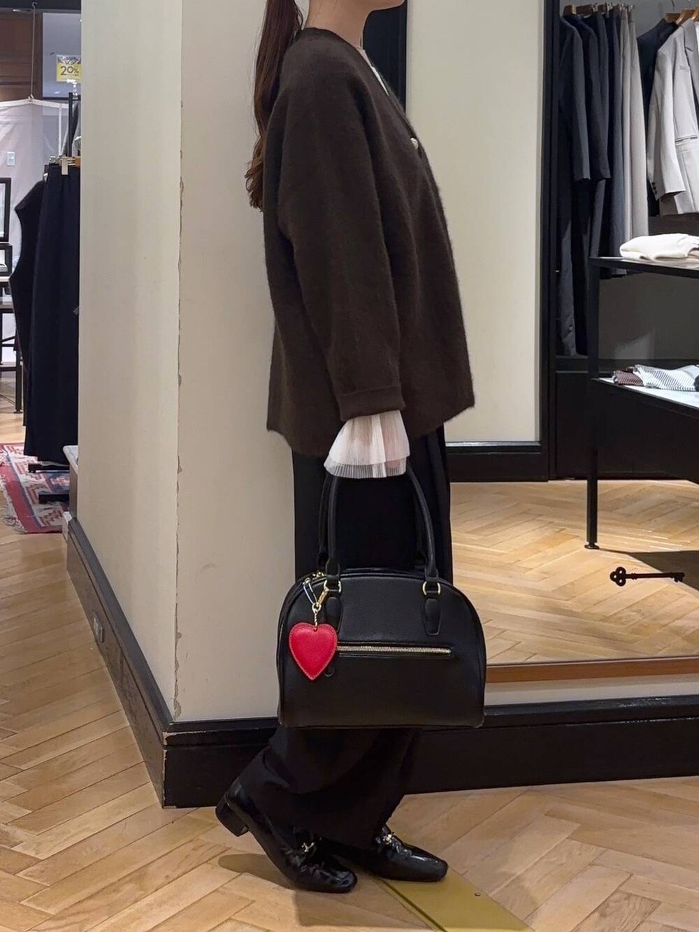 ブラウン系のカーディガン/ボレロ、ブラック系のローファー、ブラック系のスラックスを着用したレディースの秋コーディネートの2枚目の写真