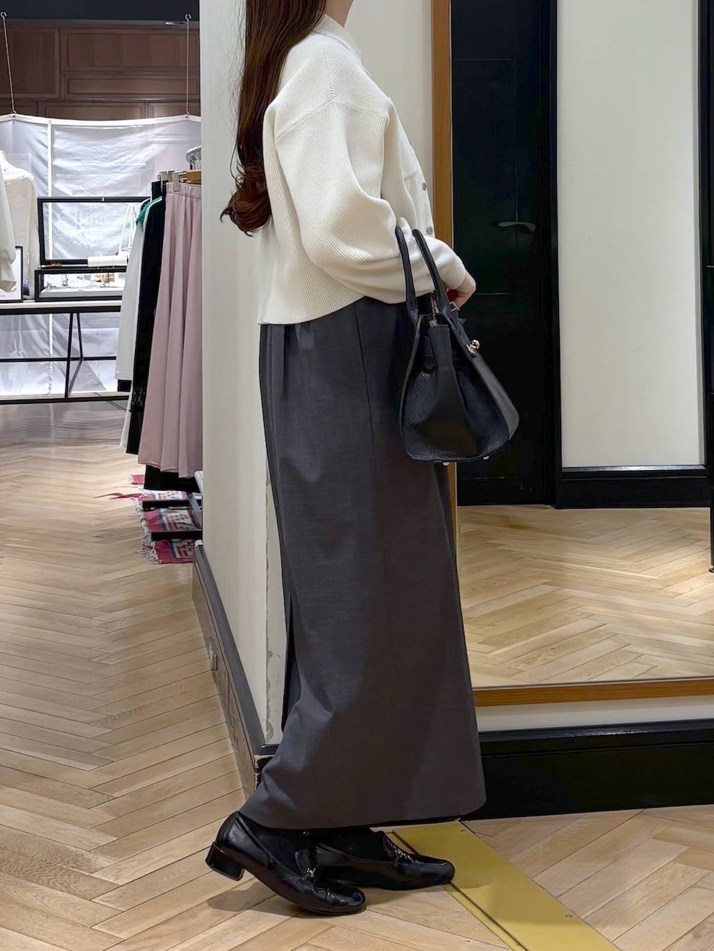 ブラック系のローファー、ブラック系のショルダーバッグ、グレー系のワンピースを着用したレディースの春コーディネートの3枚目の写真