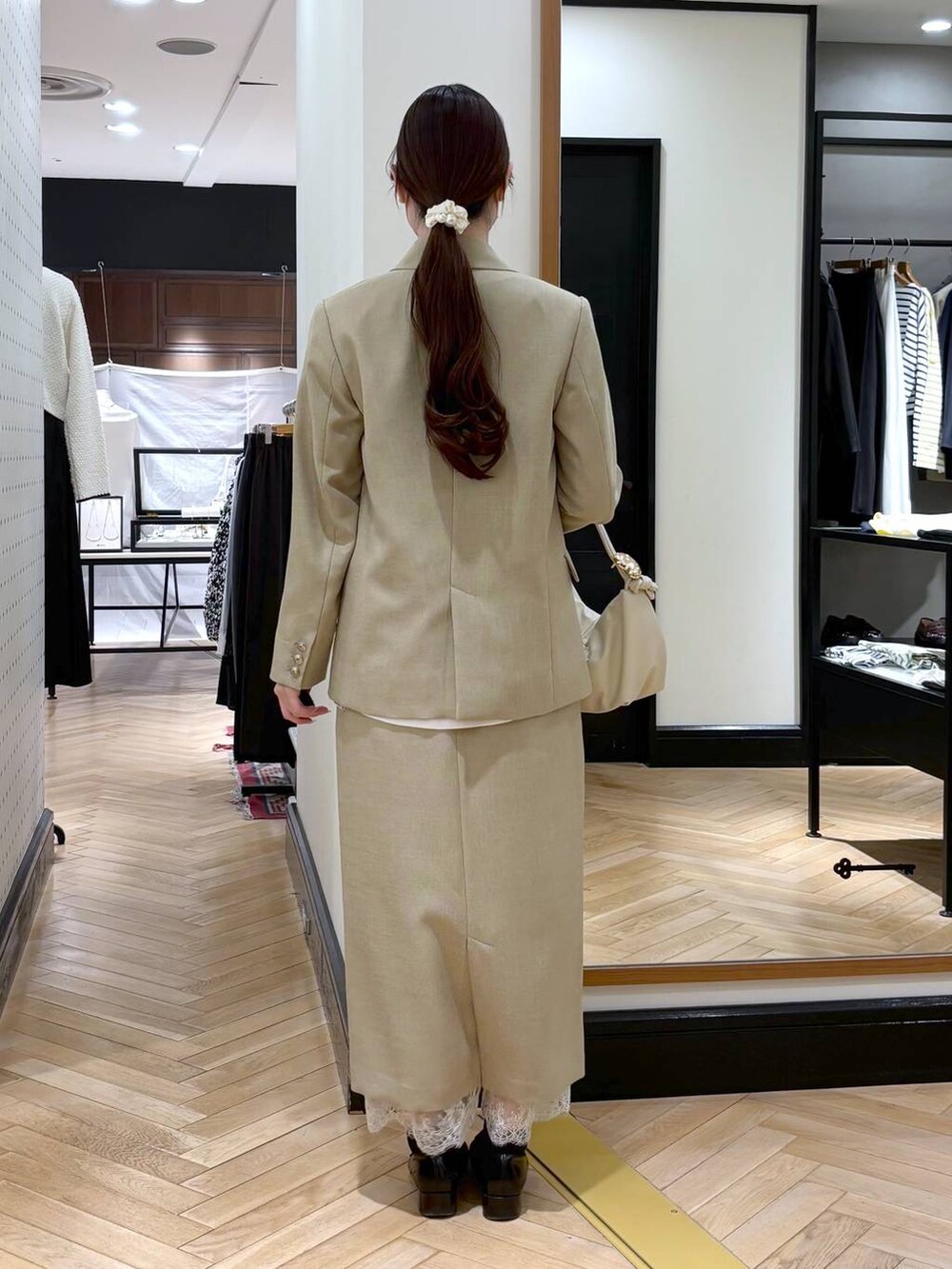 ブラック系のローファー、ベージュ系のスカート、ベージュ系のテーラードジャケットを着用したレディースの冬コーディネートの4枚目の写真