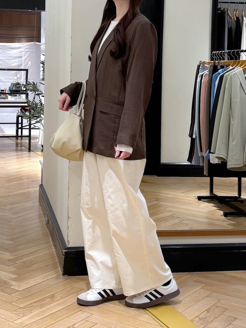 ブラウン系のテーラードジャケット、ベージュ系のショルダーバッグ、ホワイト系のTシャツ/カットソーを着用したレディースの春コーディネートの3枚目の写真