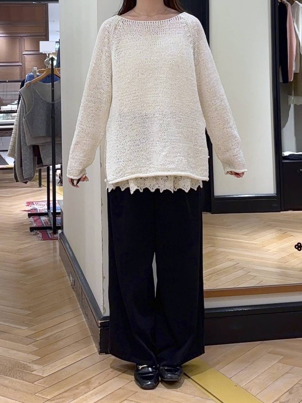 ブラック系のローファー、ブラック系のスラックス、グリーン系のショルダーバッグを着用したレディースの冬コーディネートの2枚目の写真