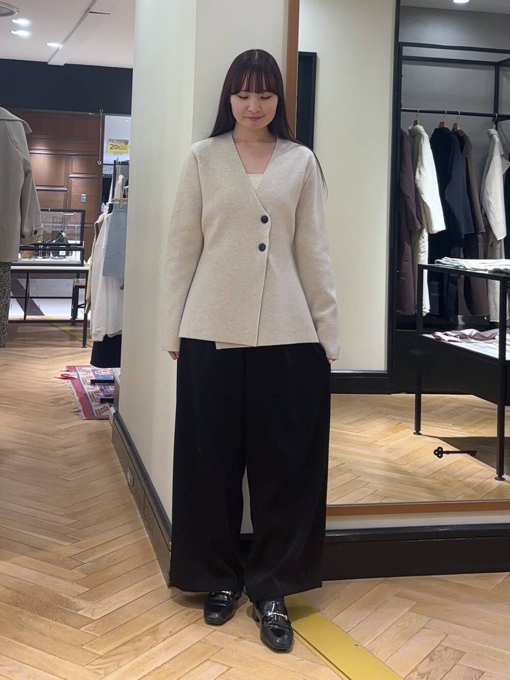 ブラック系のローファー、ブラック系のスラックス、ホワイト系のノーカラージャケットを着用したレディースの秋コーディネートの3枚目の写真