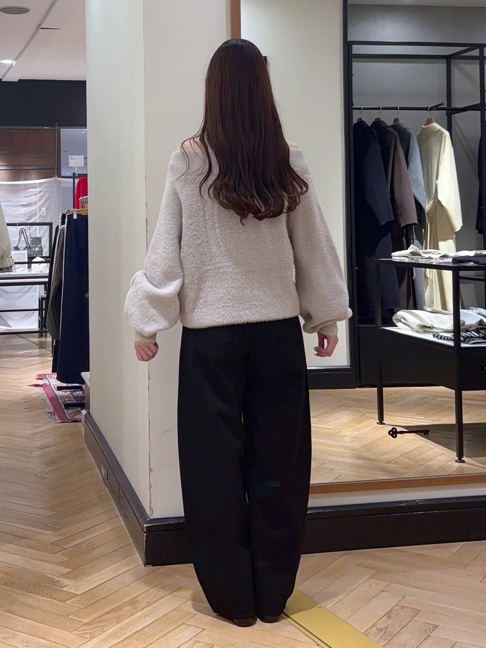 ブラック系のデニムパンツ、ブラック系のローファー、ブルー系のボストンバッグを着用したレディースの秋コーディネートの4枚目の写真