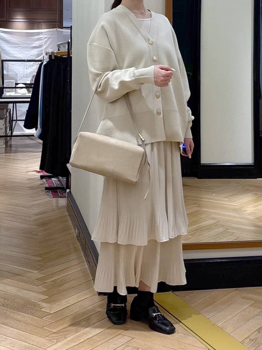 ホワイト系のスカート、ブラック系のローファー、ホワイト系のカーディガン/ボレロを着用したレディースの冬コーディネートの4枚目の写真