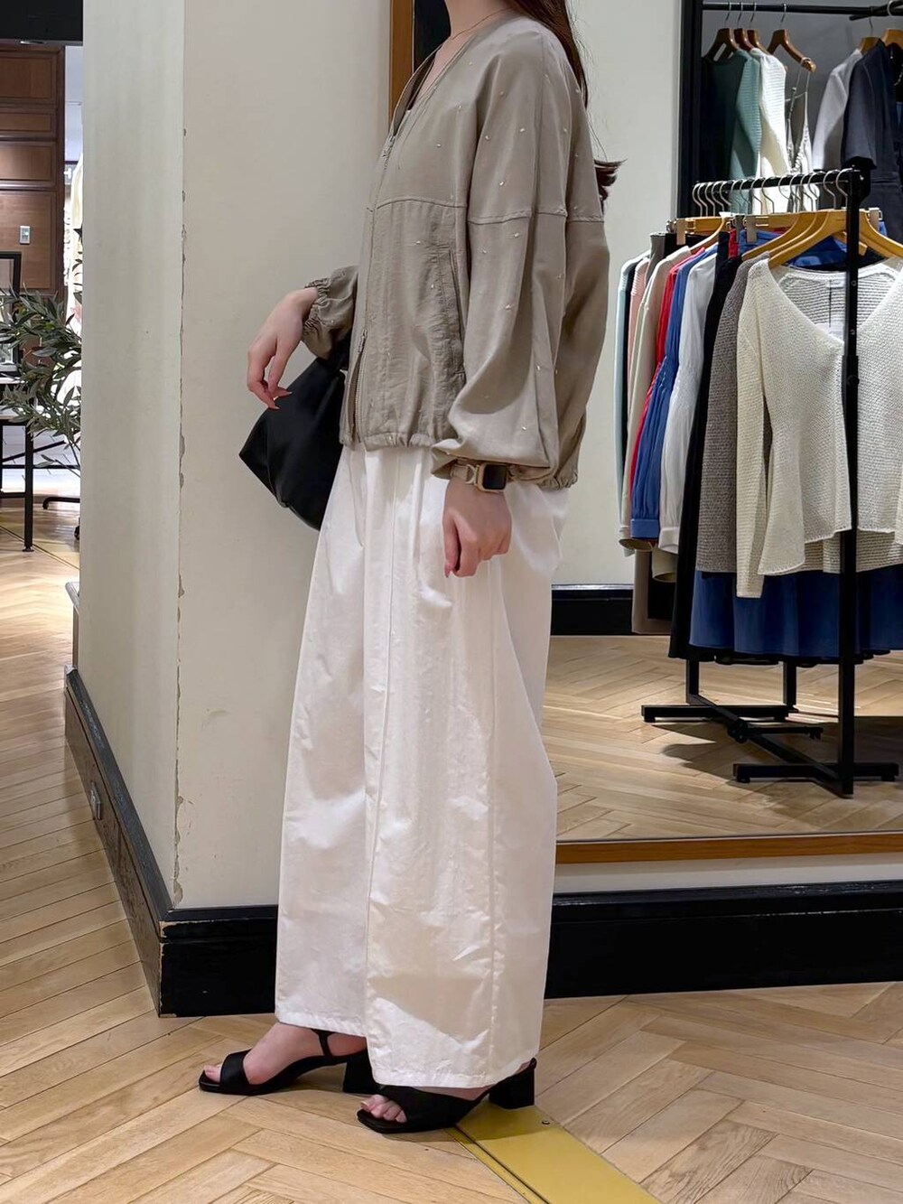 ブラック系のショルダーバッグ、ホワイト系のタンクトップ、ブラック系のサンダルを着用したレディースの春コーディネートの3枚目の写真