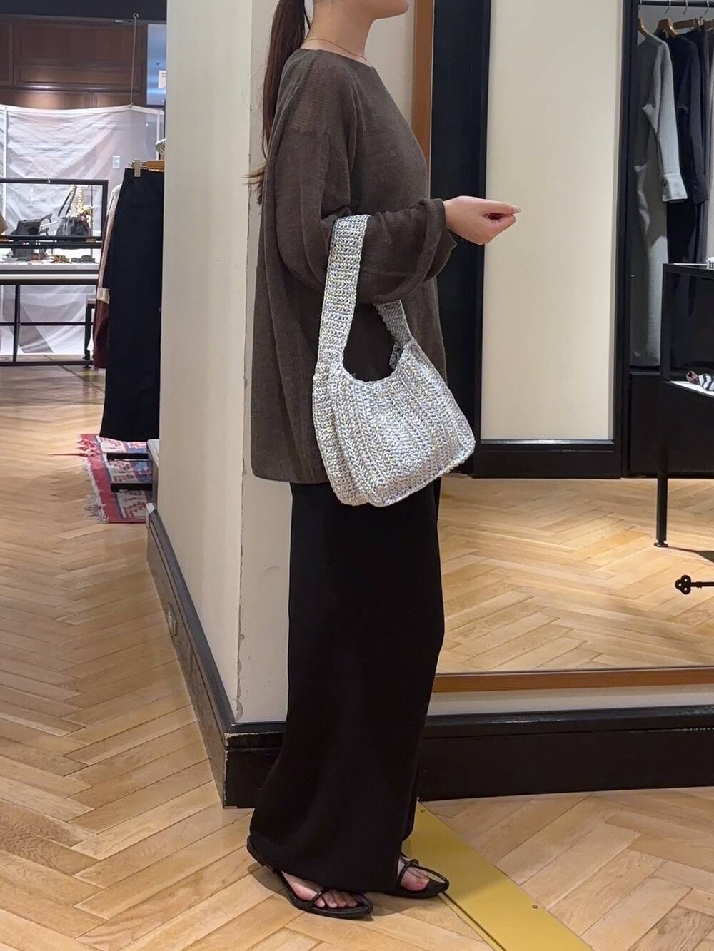 ブラウン系のニット/セーター、ブラック系のサンダル、シルバー系のハンドバッグを着用したレディースの秋コーディネートの3枚目の写真