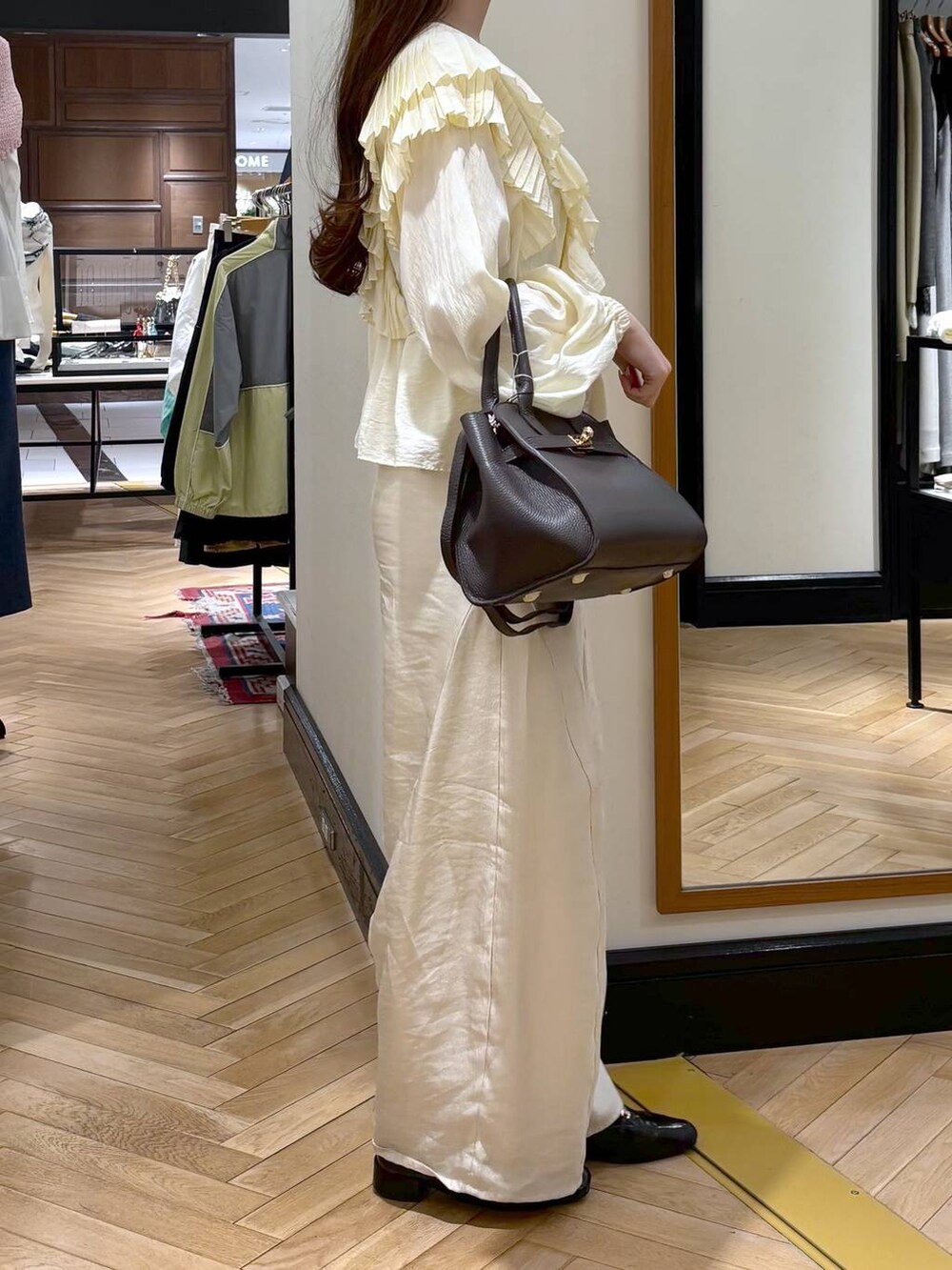 ブラック系のローファー、ホワイト系のその他パンツ、ブラウン系のショルダーバッグを着用したレディースの春コーディネートの2枚目の写真