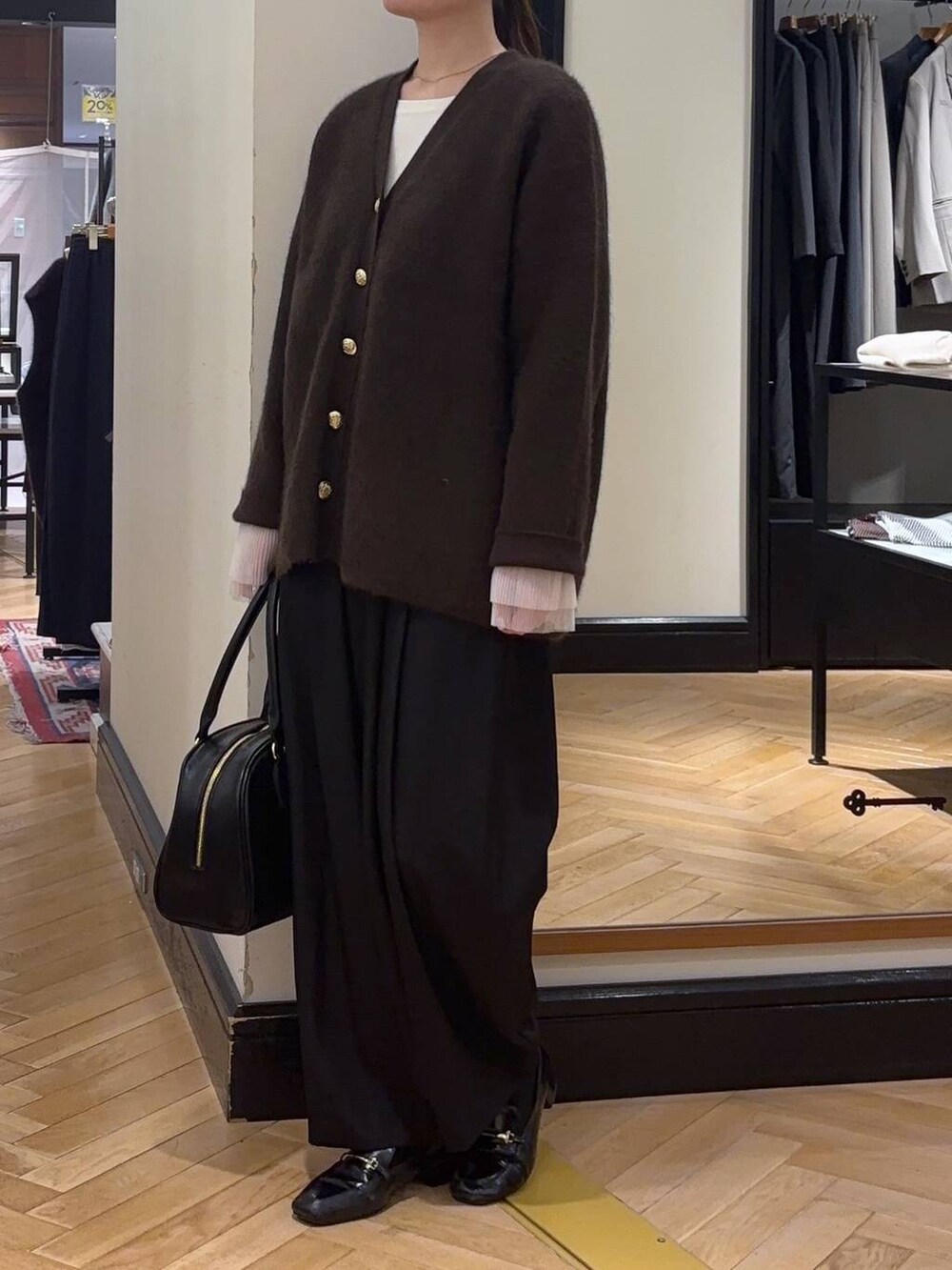 ブラウン系のカーディガン/ボレロ、ブラック系のローファー、ブラック系のスラックスを着用したレディースの秋コーディネートの4枚目の写真