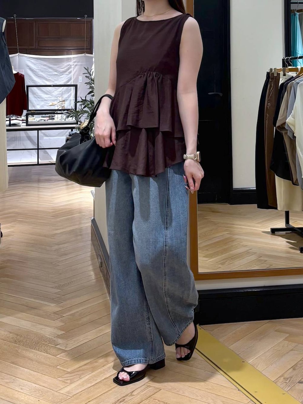 ブルー系のデニムパンツ、ブラック系のショルダーバッグ、ブラック系のパンプスを着用したレディースの夏コーディネートの3枚目の写真
